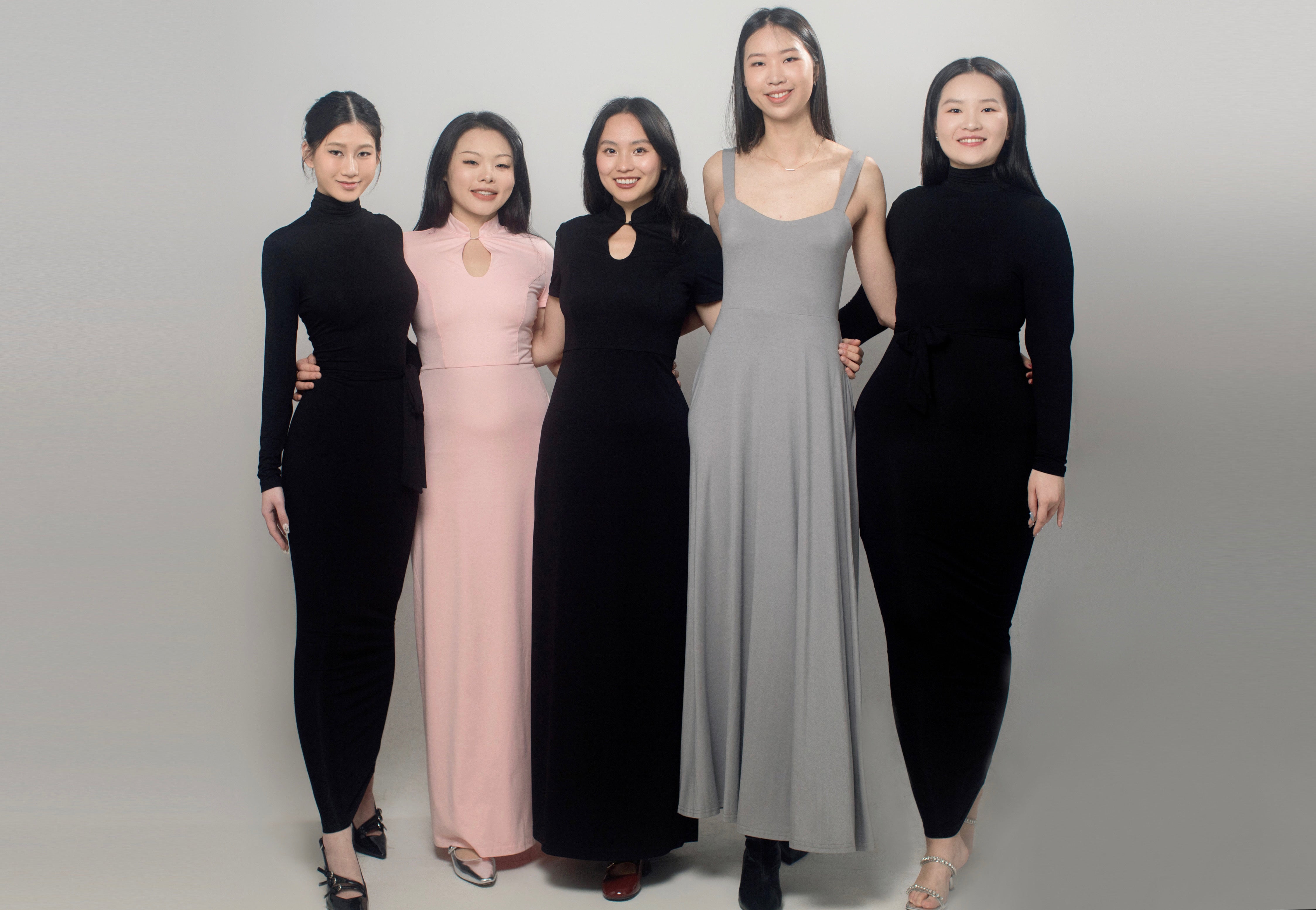 5 models dressed in YÁNG - from left to right: Dawn maxi dress, Mei dress in pink, Mei dress in black, Colette dress, Dawn maxi dress