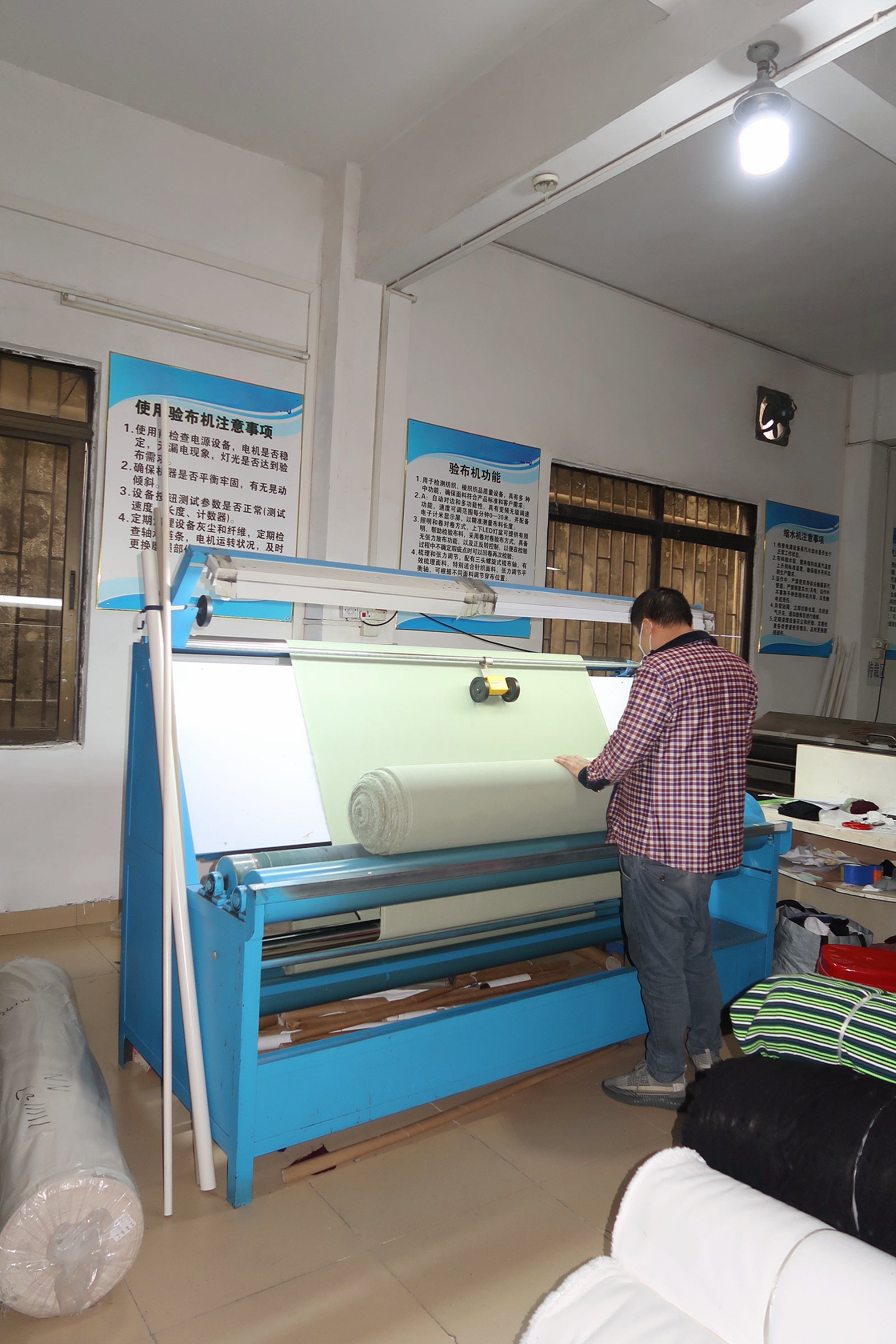 A worker is using a machine to test the fabric